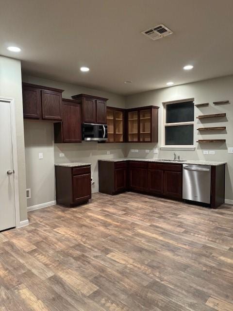 kitchen with dark brown cabinetry, sink, light hardwood / wood-style floors, and appliances with stainless steel finishes