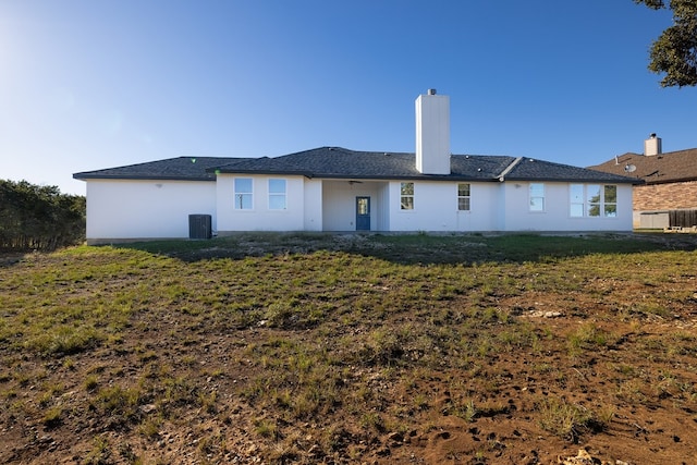 rear view of property featuring central AC unit and a yard