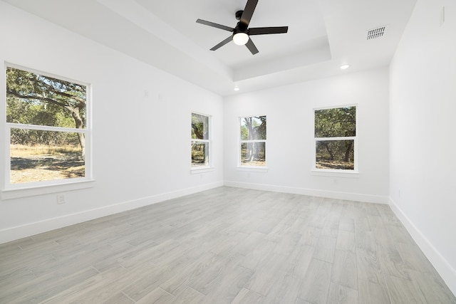 spare room featuring ceiling fan, a wealth of natural light, and light hardwood / wood-style flooring