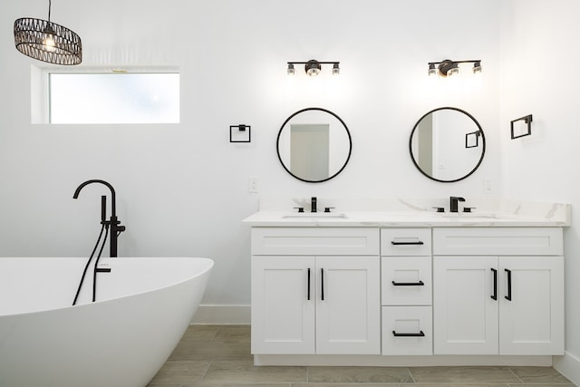 bathroom with a bathing tub, vanity, and a chandelier