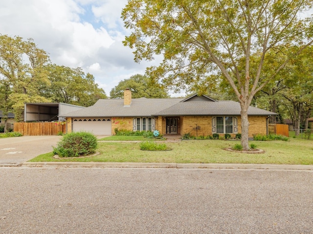 ranch-style house featuring a front yard, a garage, and a carport