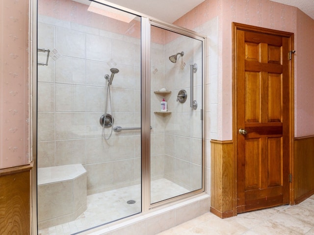 bathroom with tile patterned floors and a shower with door