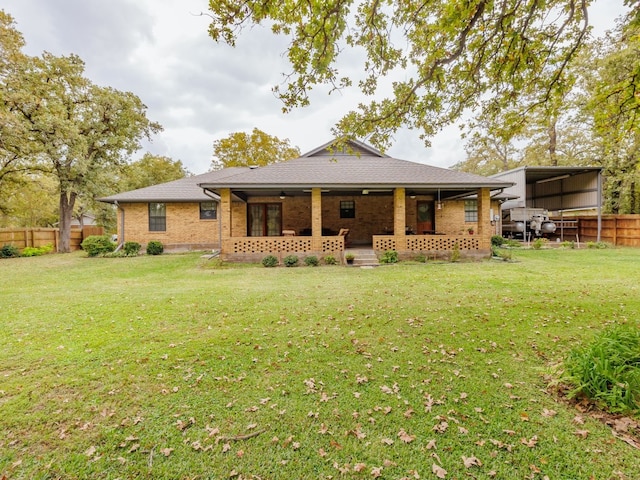 rear view of property with a carport and a lawn