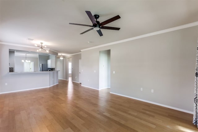 unfurnished living room featuring ceiling fan with notable chandelier, light hardwood / wood-style flooring, and ornamental molding