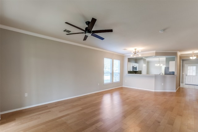 unfurnished living room with a wealth of natural light, light hardwood / wood-style flooring, ceiling fan with notable chandelier, and ornamental molding