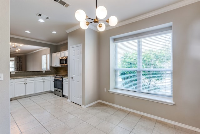 kitchen featuring white cabinetry, a notable chandelier, pendant lighting, decorative backsplash, and appliances with stainless steel finishes