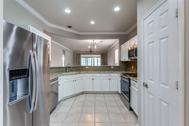 kitchen with white cabinets, light stone countertops, crown molding, and appliances with stainless steel finishes