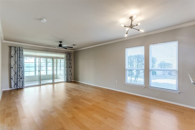 empty room with ceiling fan with notable chandelier, light hardwood / wood-style flooring, and crown molding