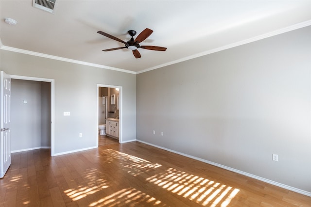 unfurnished bedroom with ensuite bath, ceiling fan, hardwood / wood-style floors, and crown molding