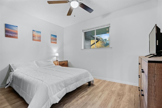 bedroom with wood-type flooring, a textured ceiling, and ceiling fan