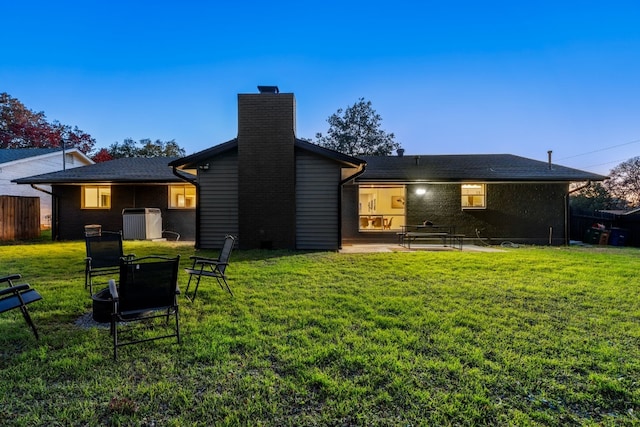 rear view of property with a yard, central AC unit, and a patio area