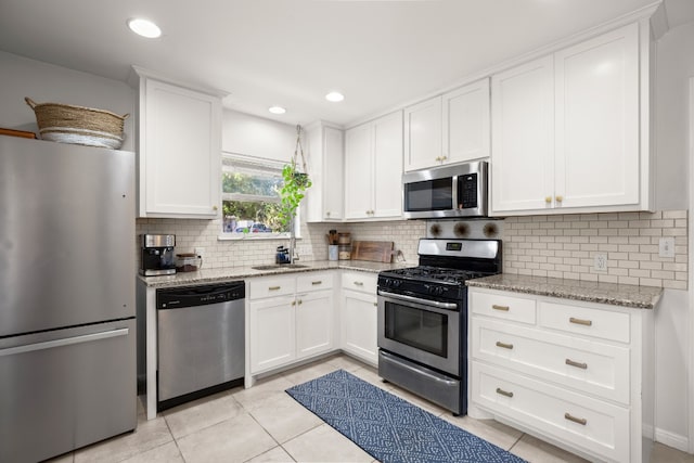 kitchen featuring white cabinets, light tile patterned floors, stainless steel appliances, and sink