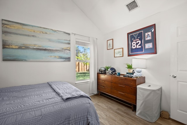 bedroom with light wood-type flooring and vaulted ceiling