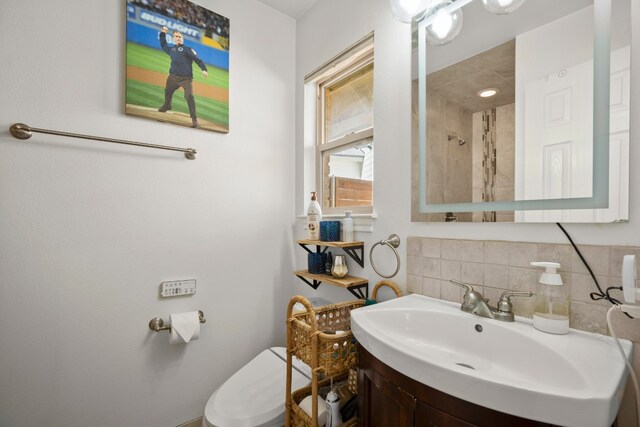 bathroom with decorative backsplash, toilet, and vanity