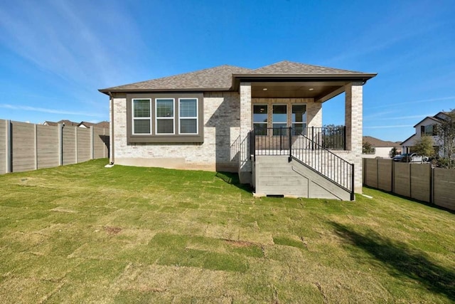 rear view of property featuring a lawn