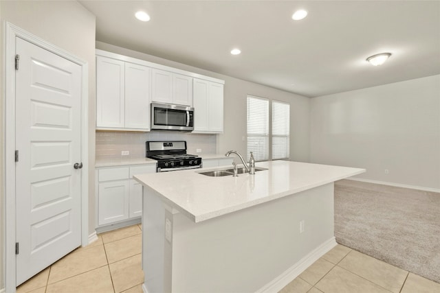 kitchen featuring white cabinets, sink, an island with sink, and appliances with stainless steel finishes