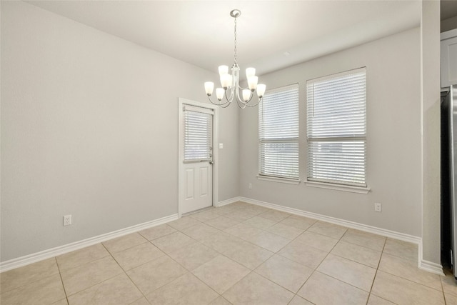 empty room featuring light tile patterned floors and a notable chandelier