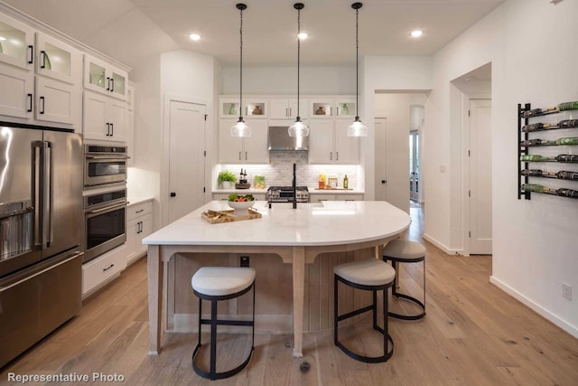 kitchen featuring a center island with sink, white cabinets, light hardwood / wood-style floors, and appliances with stainless steel finishes