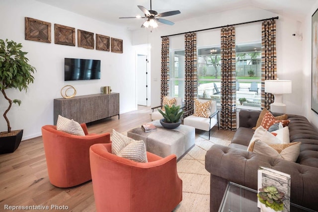 living room featuring vaulted ceiling, light hardwood / wood-style flooring, and ceiling fan