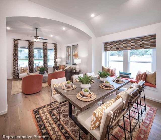 dining space featuring hardwood / wood-style floors, ceiling fan, and lofted ceiling