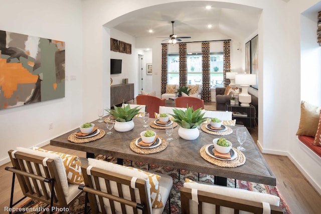 dining space with hardwood / wood-style flooring, ceiling fan, and lofted ceiling