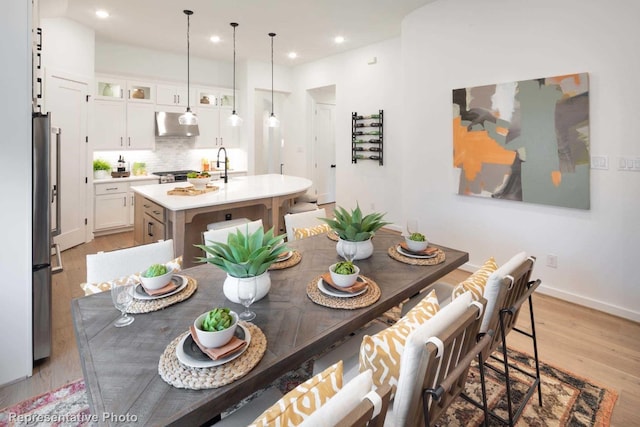 dining area with light hardwood / wood-style flooring and sink