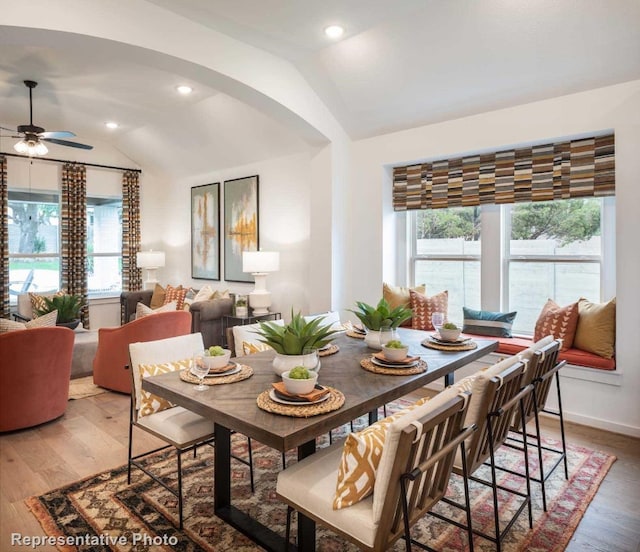 dining area featuring hardwood / wood-style floors, ceiling fan, a healthy amount of sunlight, and vaulted ceiling