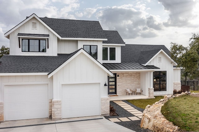 modern farmhouse featuring covered porch and a garage