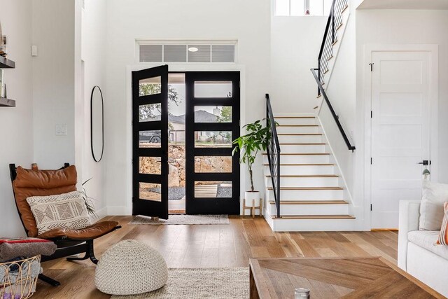 foyer entrance with hardwood / wood-style floors, a high ceiling, and a wealth of natural light