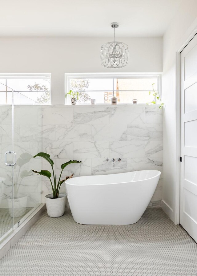 bathroom with separate shower and tub and tile walls