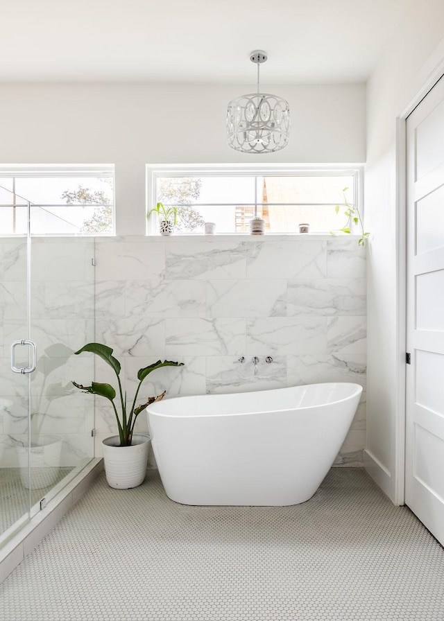 bathroom featuring tile walls and plus walk in shower