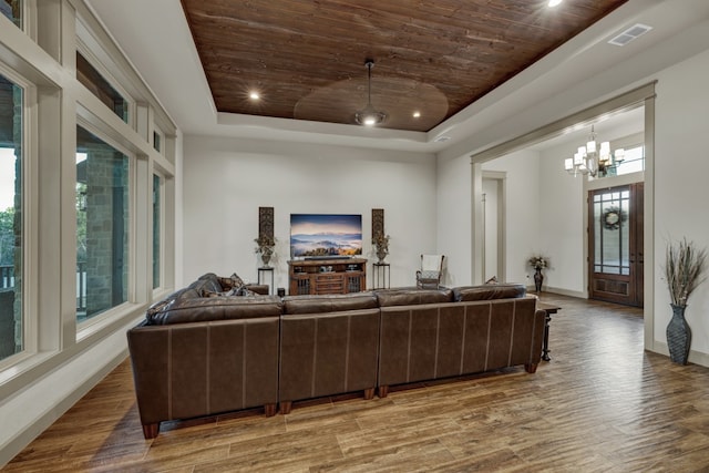 living room with hardwood / wood-style floors, a raised ceiling, and a wealth of natural light