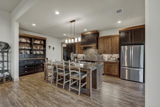 121 Winecup Ln, Spring Branch, TX 78070 - kitchen featuring stainless steel appliances, decorative backsplash, wood finished floors, recessed lighting, and a kitchen breakfast bar