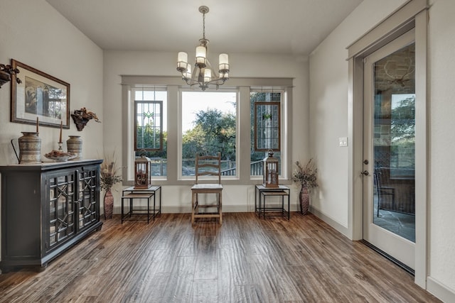 unfurnished room featuring a notable chandelier and hardwood / wood-style flooring