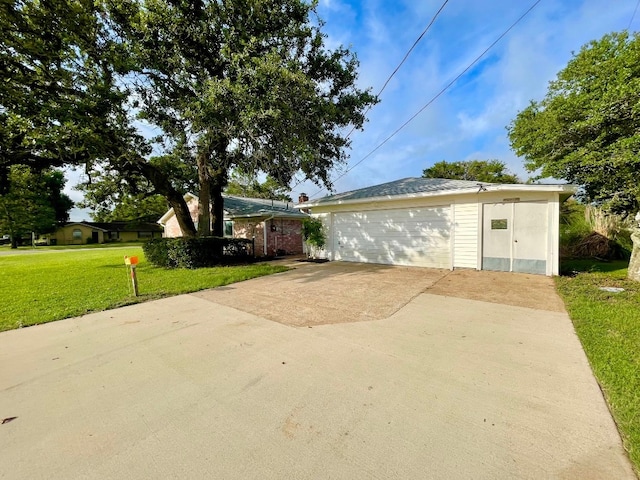 view of side of home featuring a garage, an outbuilding, and a yard