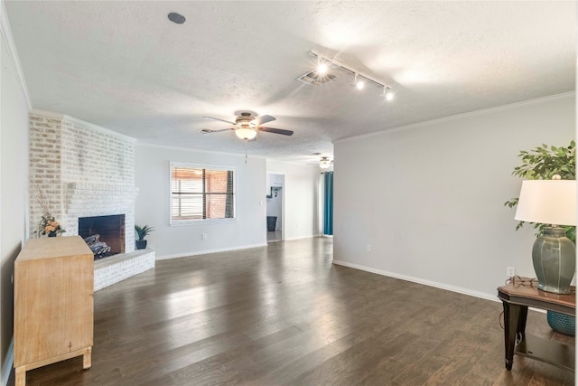 living room featuring a textured ceiling, crown molding, dark hardwood / wood-style flooring, and a fireplace