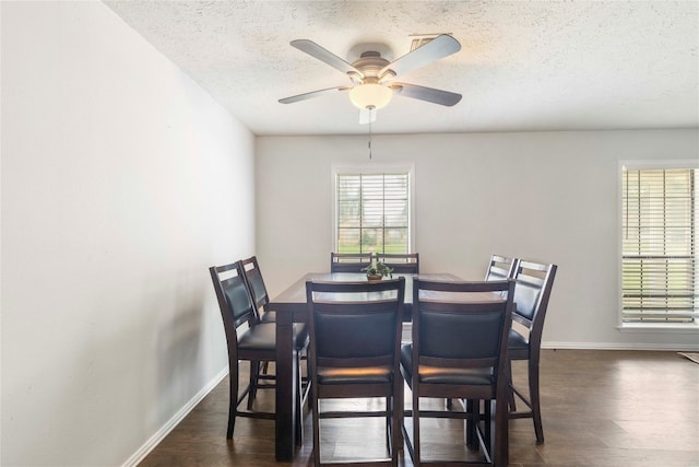 dining room with dark hardwood / wood-style floors, ceiling fan, and a textured ceiling