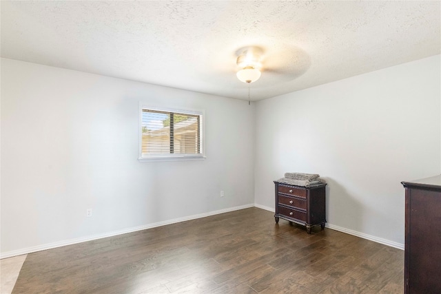 spare room with dark hardwood / wood-style flooring and a textured ceiling