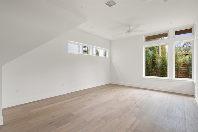 additional living space featuring ceiling fan, a healthy amount of sunlight, and light wood-type flooring