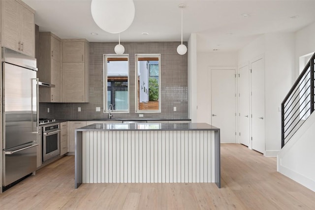900 S 2nd St Unit 18, Austin, TX 78704 - kitchen with appliances with stainless steel finishes, a sink, a kitchen island, and light wood-style flooring