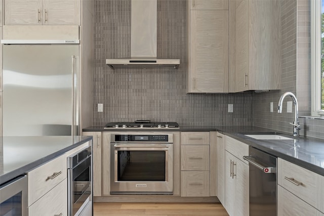 kitchen with wall chimney exhaust hood, stainless steel appliances, sink, light hardwood / wood-style floors, and wine cooler