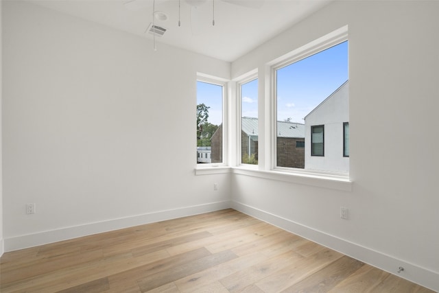 empty room with ceiling fan and light hardwood / wood-style flooring