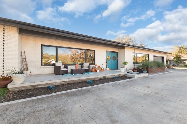 back of house featuring outdoor lounge area and a patio area