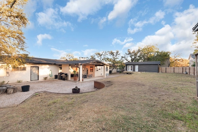 rear view of house featuring a lawn and a patio