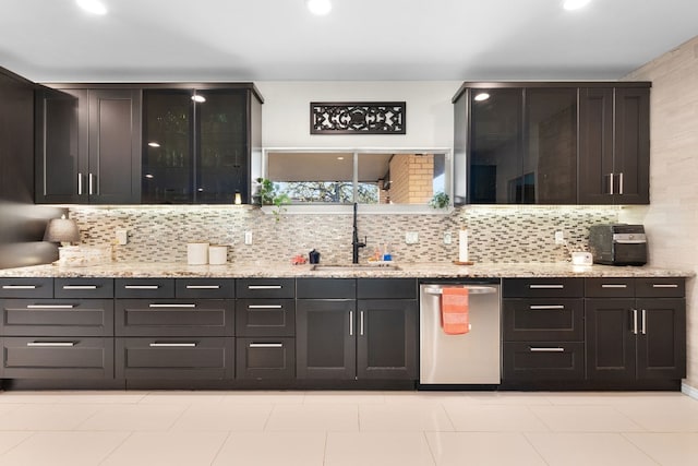 kitchen with backsplash, dishwasher, sink, and light stone counters