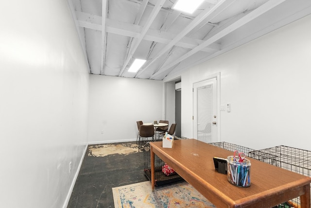 home office with concrete flooring, a wall mounted AC, and lofted ceiling