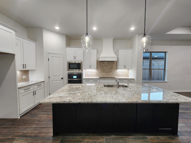 kitchen with premium range hood, hanging light fixtures, a large island, and built in microwave