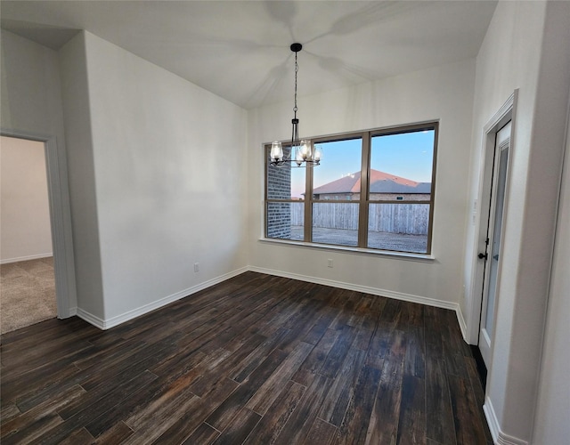 unfurnished dining area featuring a notable chandelier and dark hardwood / wood-style flooring