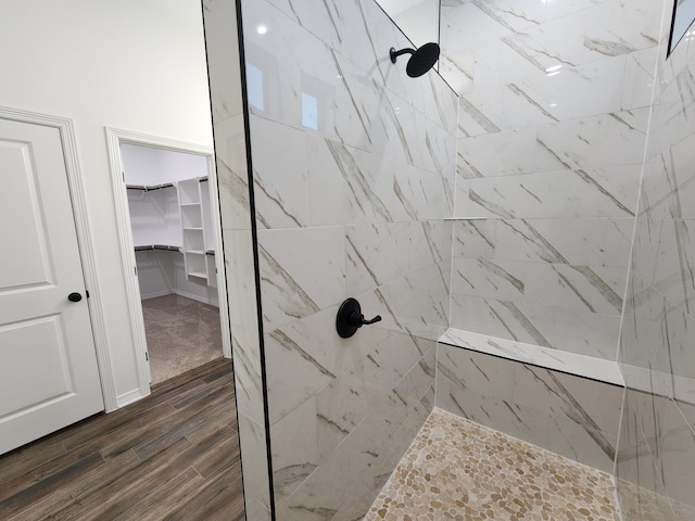 bathroom featuring hardwood / wood-style flooring and tiled shower