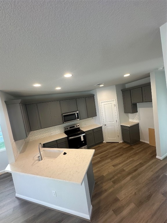 kitchen with stainless steel appliances, gray cabinets, dark hardwood / wood-style floors, and sink